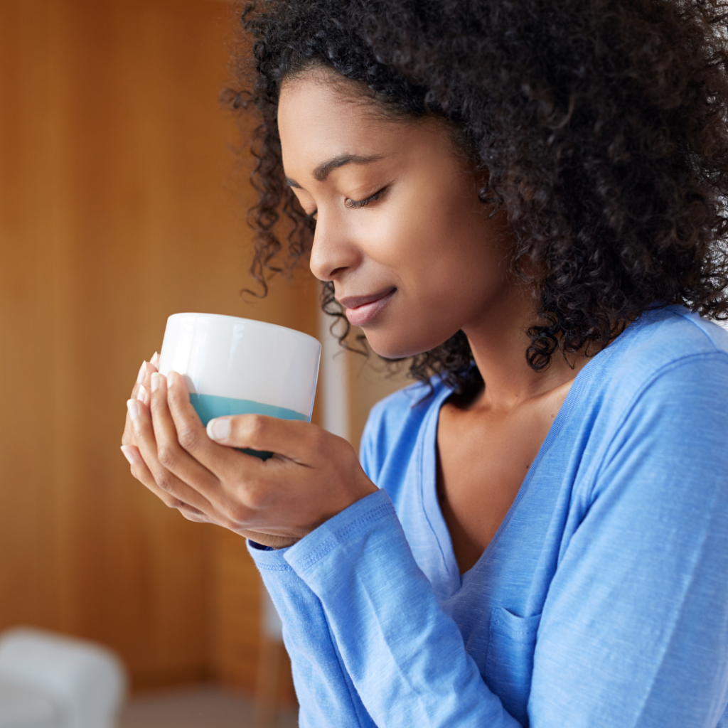 woman holding a coffee cup with her eyes closed