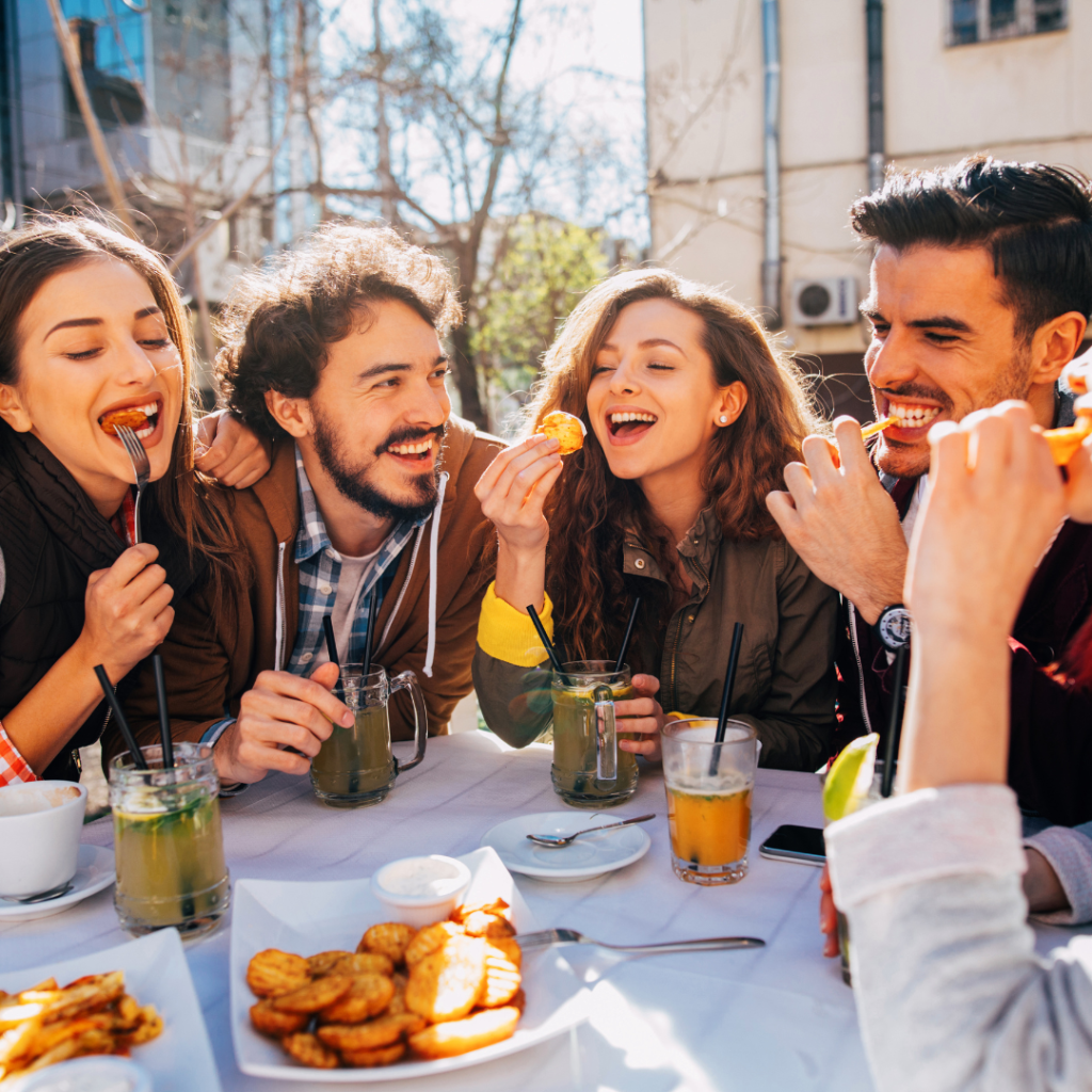 friends happy gathering around eating food and laughing